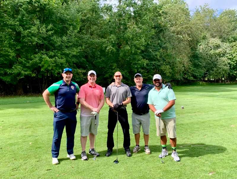 5 men standing on the golf course
